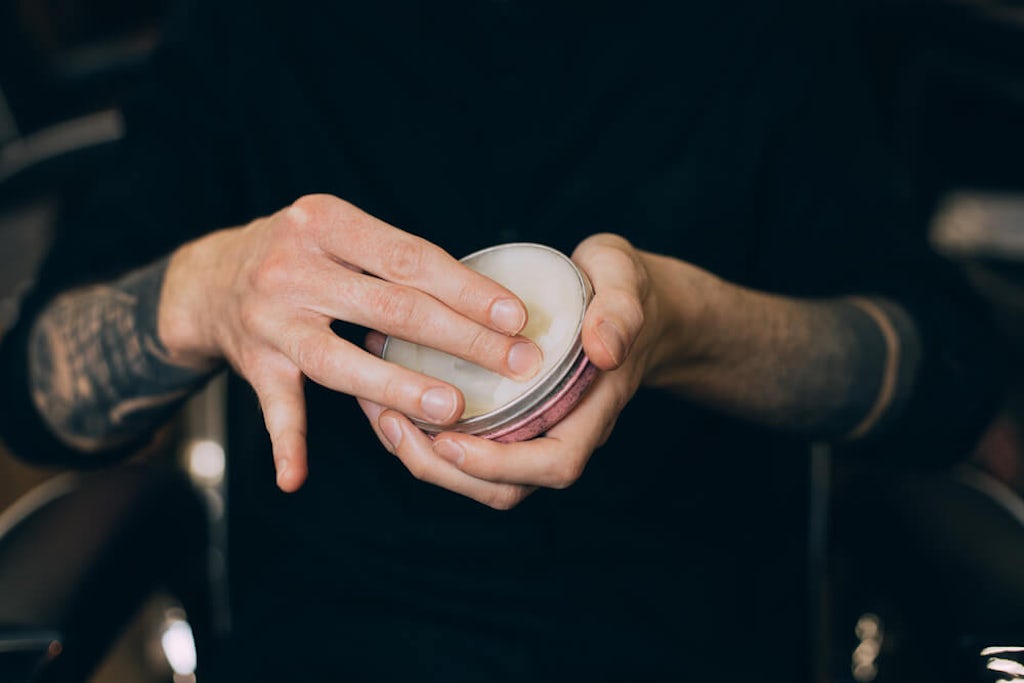Taking cannabis balm out of a tin