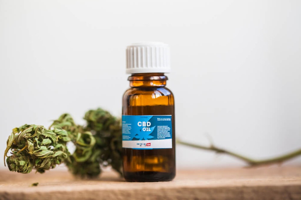 A bottle of CBD oil and hemp flower