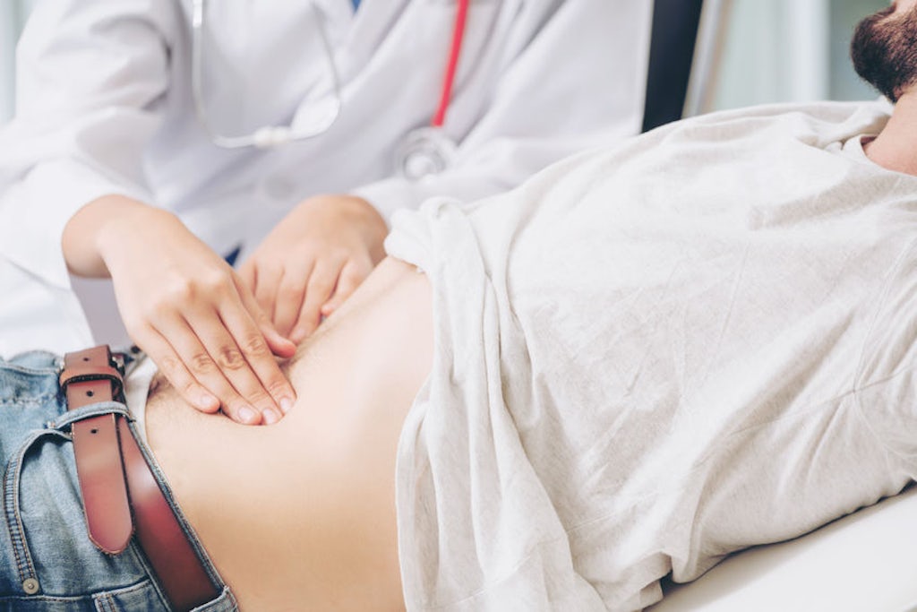 A doctor examines a patient's abdomen