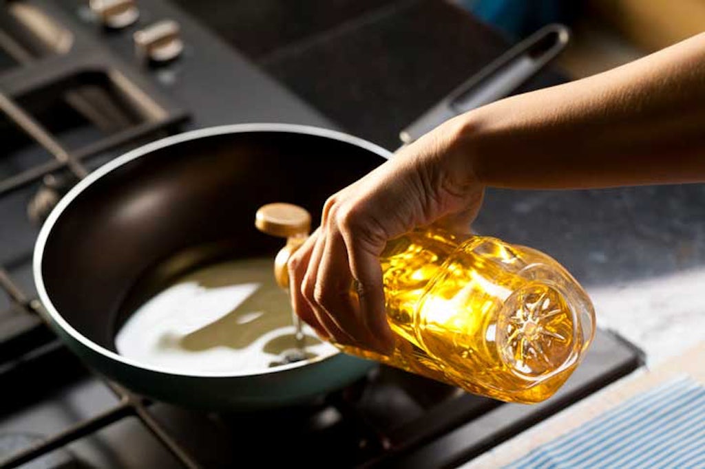 Pouring oil into a pot for making cannabis oil