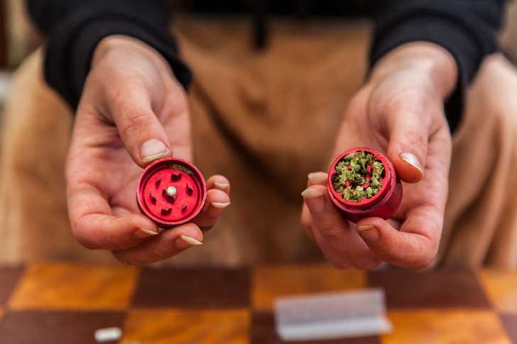 Breaking up cannabis in a grinder